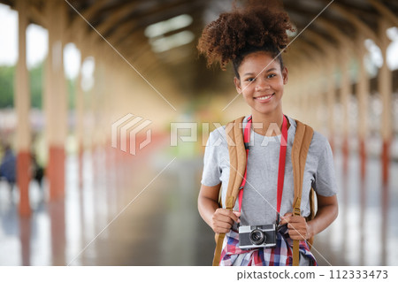 Young Asian African woman traveler with backpack in the railway train station, traveler girl walking stand sit waiting take a picture on railway platform train station. High quality photo Young Asian African woman traveler with backpack in the railway train station, traveler girl walking stand sit waiting take a picture on railway platform train station. High quality photo 112333473