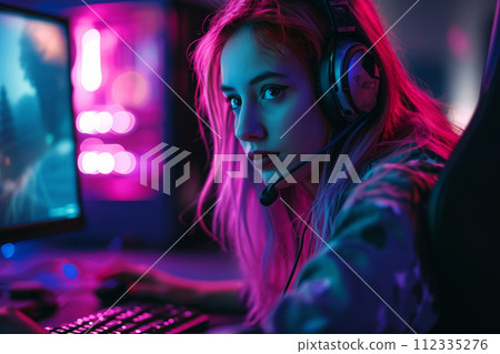 Female gamer using computer in room with neon lights 112335276