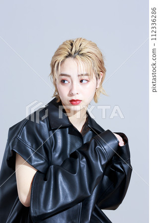 一個穿著時尚衣服的年輕女人 112336286