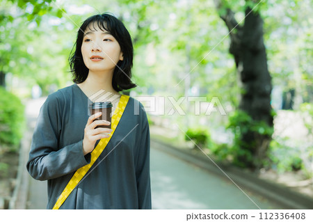 端著咖啡走路的女人 112336408