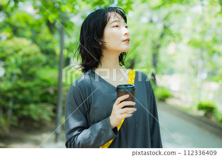 Woman walking with coffee 112336409