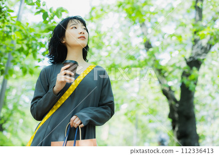 Woman walking with coffee 112336413