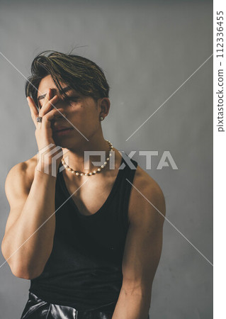 灰色背景中穿著背心的肌肉發達的年輕人 112336455