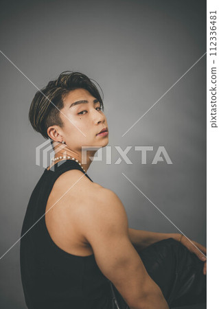 灰色背景中穿著背心的肌肉發達的年輕人 灰色背景中穿著背心的肌肉發達的年輕人 112336481
