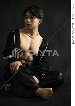 A young and handsome man with amazing muscles on a black background A young and handsome man with amazing muscles on a black background 112336539