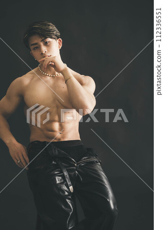 Shirtless muscular young man over black background Shirtless muscular young man over black background 112336551