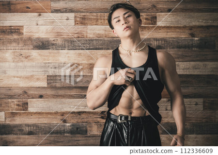木質背景中穿著背心的肌肉發達的年輕人 112336609