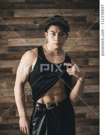 黑色背心站在木頭背景下的肌肉年輕人 黑色背心站在木頭背景下的肌肉年輕人 112336697