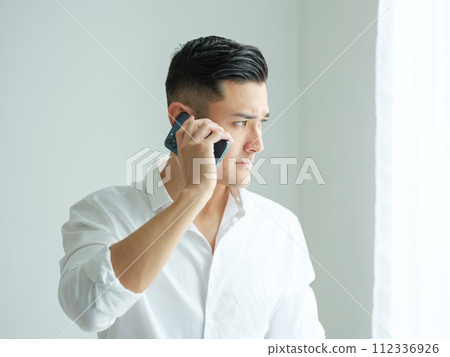 man on the phone by the window 112336926