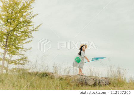 Girl running around with a butterfly net Girl running around with a butterfly net 112337265
