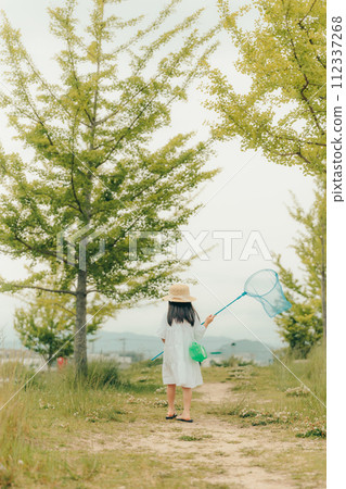 Girl running around with a butterfly net 112337268