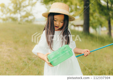 Girl running around with a butterfly net 112337304