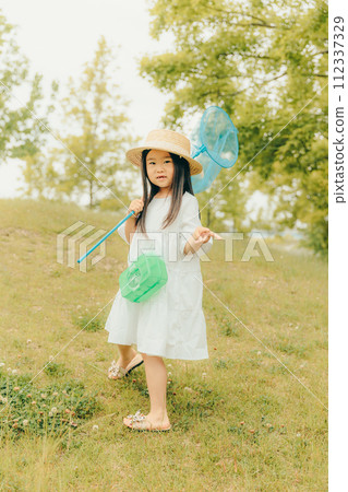 Girl running around with a butterfly net 112337329