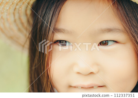 A girl wearing a straw hat A girl wearing a straw hat 112337351