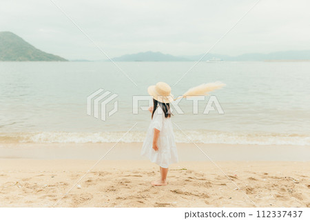 Girl with dried flowers on the beach Girl with dried flowers on the beach 112337437