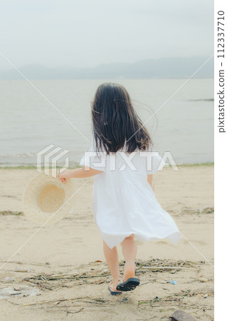 girl walking on the beach 112337710