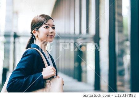 Businesswoman with office building in the background Businesswoman with office building in the background 112337888