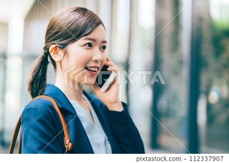 A young woman making a phone call outdoors 112337907