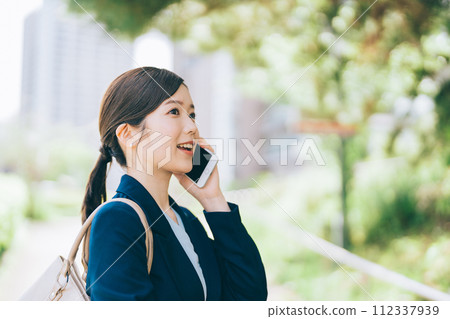 Young businesswoman making a phone call outdoors 112337939