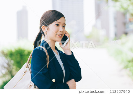 Young businesswoman making a phone call outdoors Young businesswoman making a phone call outdoors 112337940
