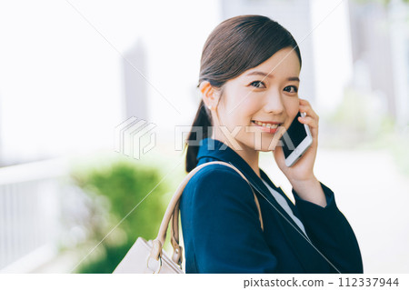 年輕女商人在戶外打電話 112337944