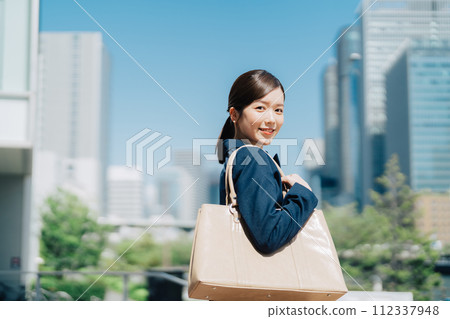 Businesswoman with blue sky and office building in the background 112337948