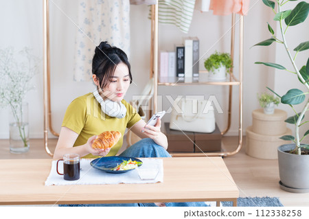 A young woman eating breakfast  A young woman eating breakfast  112338258