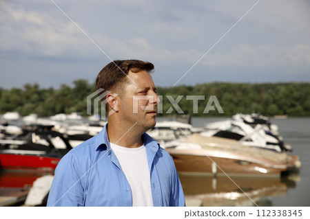 Man at port with Yachts in the background Man at port with Yachts in the background 112338345