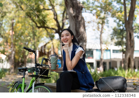 Businesswoman ride bicycle sit outside working Entrepreneur commuting by cycling reduce carbon footprint. Bike to work eco friendly alternative vehicle green energy 112338348