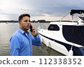 Man talking on the phone beside luxury yacht at port. Nautical and marine concept 112338352