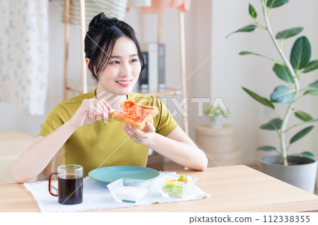A young woman eating breakfast A young woman eating breakfast 112338355