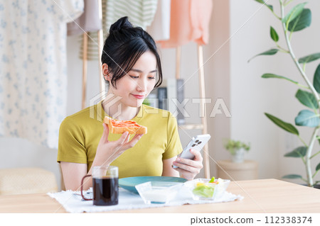 A young woman eating breakfast　 112338374