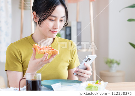 A young woman eating breakfast　 112338375