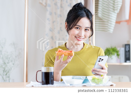 A young woman eating breakfast A young woman eating breakfast 112338381
