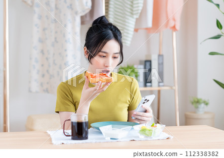 A young woman eating breakfast A young woman eating breakfast 112338382