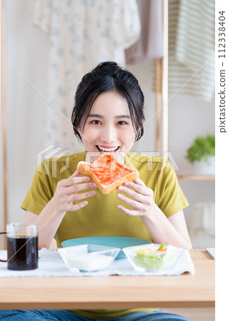 A young woman eating breakfast　 112338404