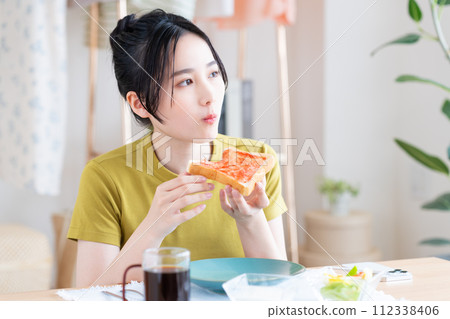 A young woman eating breakfast A young woman eating breakfast 112338406