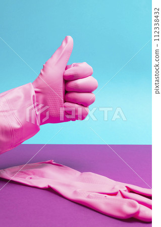 Hand in Pink latex glove giving thumbs up sign 112338432