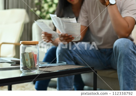 Cropped shot of stressed young couple discussing unpaid debt or money problems at home Cropped shot of stressed young couple discussing unpaid debt or money problems at home 112338792