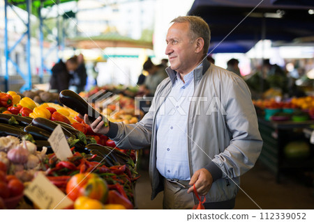 Man choosing vegetables in greengrocery 112339052