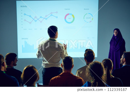 Business expert delivering presentation to audience, with focus on neural network graphic, while worker asks question. Business expert delivering presentation to audience, with focus on neural network graphic, while worker asks question. 112339187