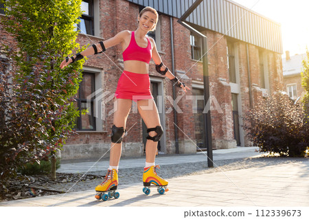 Woman skating in the street on a nice sunny day 112339673