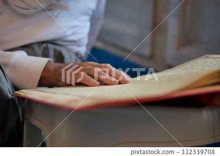 muslim man hand holding Holy book Quran at mosque muslim man hand holding Holy book Quran at mosque 112339708