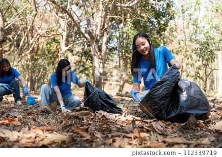 Young people friend volunteer collecting garbage plastic bottles to trash bags. environmental care ecology concept 112339719