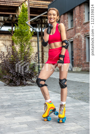 Pretty woman on rollerblades posing in park Pretty woman on rollerblades posing in park 112339814