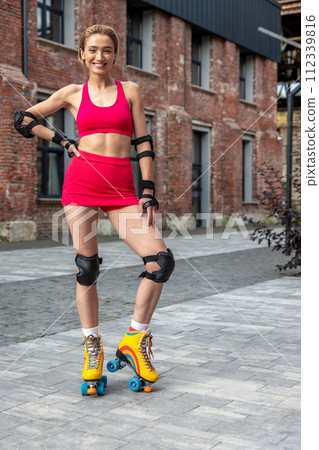 Pretty woman on rollerblades posing in park Pretty woman on rollerblades posing in park 112339816