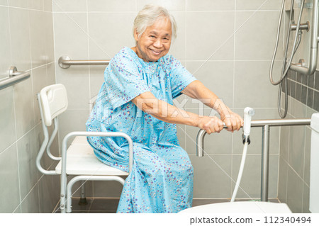 Asian elderly woman patient use toilet bathroom handle security in nursing hospital, healthy strong medical concept. 112340494