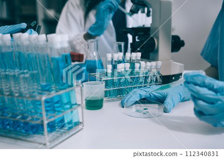 Scientist works with a pipette and a test tube. Scientific laboratory of biotechnology, development of medicine and research in chemistry, biochemistry and experiments. 112340831