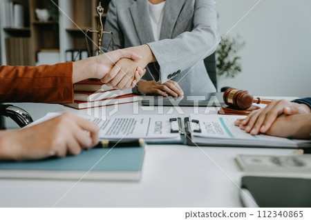 Middle age partner lawyers attorneys shaking hands after discussing a contract agreement done. Middle age partner lawyers attorneys shaking hands after discussing a contract agreement done. 112340865