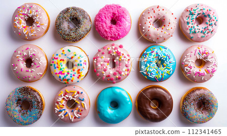 Many delicious donuts. Assorted glazed donuts with colorful sprinkles. 112341465